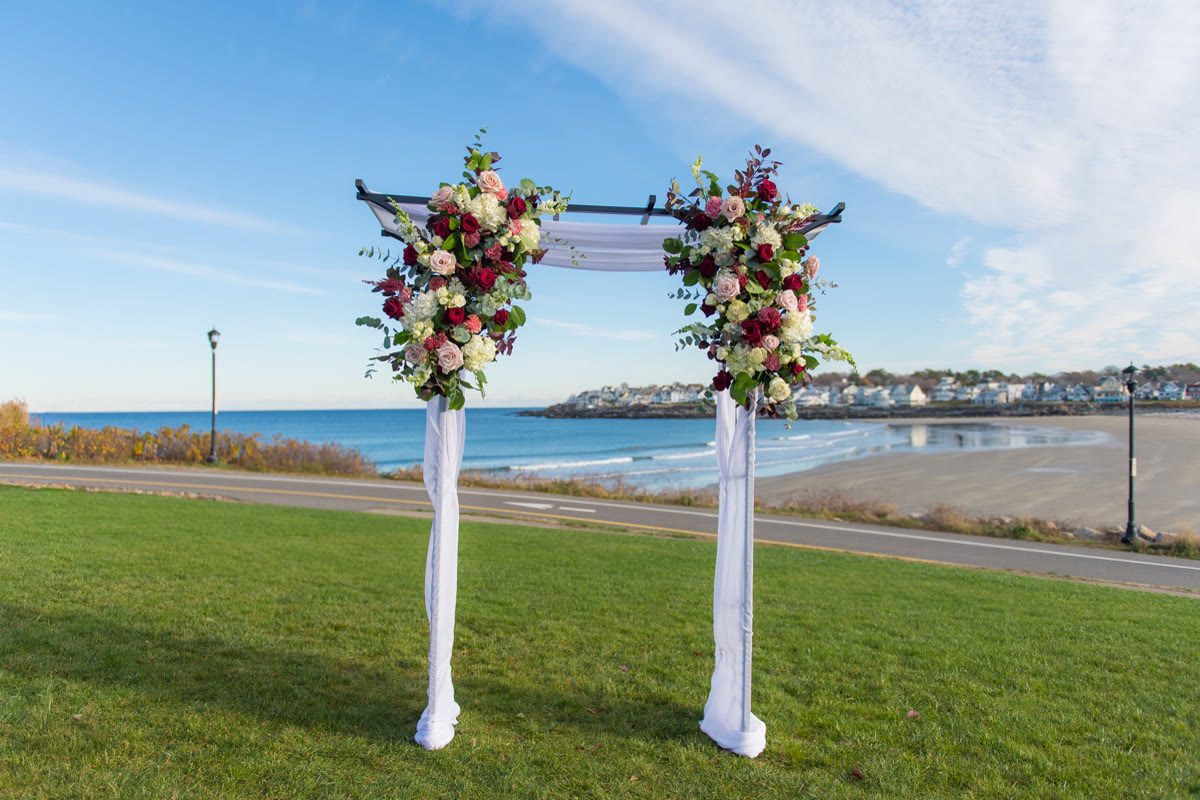 Floral ceremony arch on the oceanfront lawn
