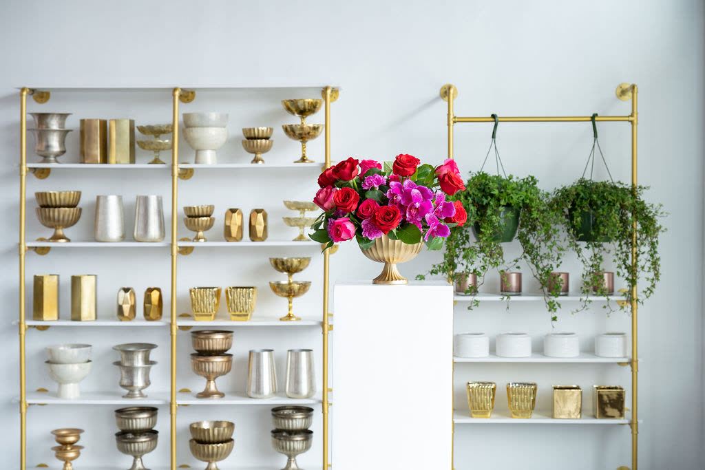 The studio shelves stocked with vessels and blooms