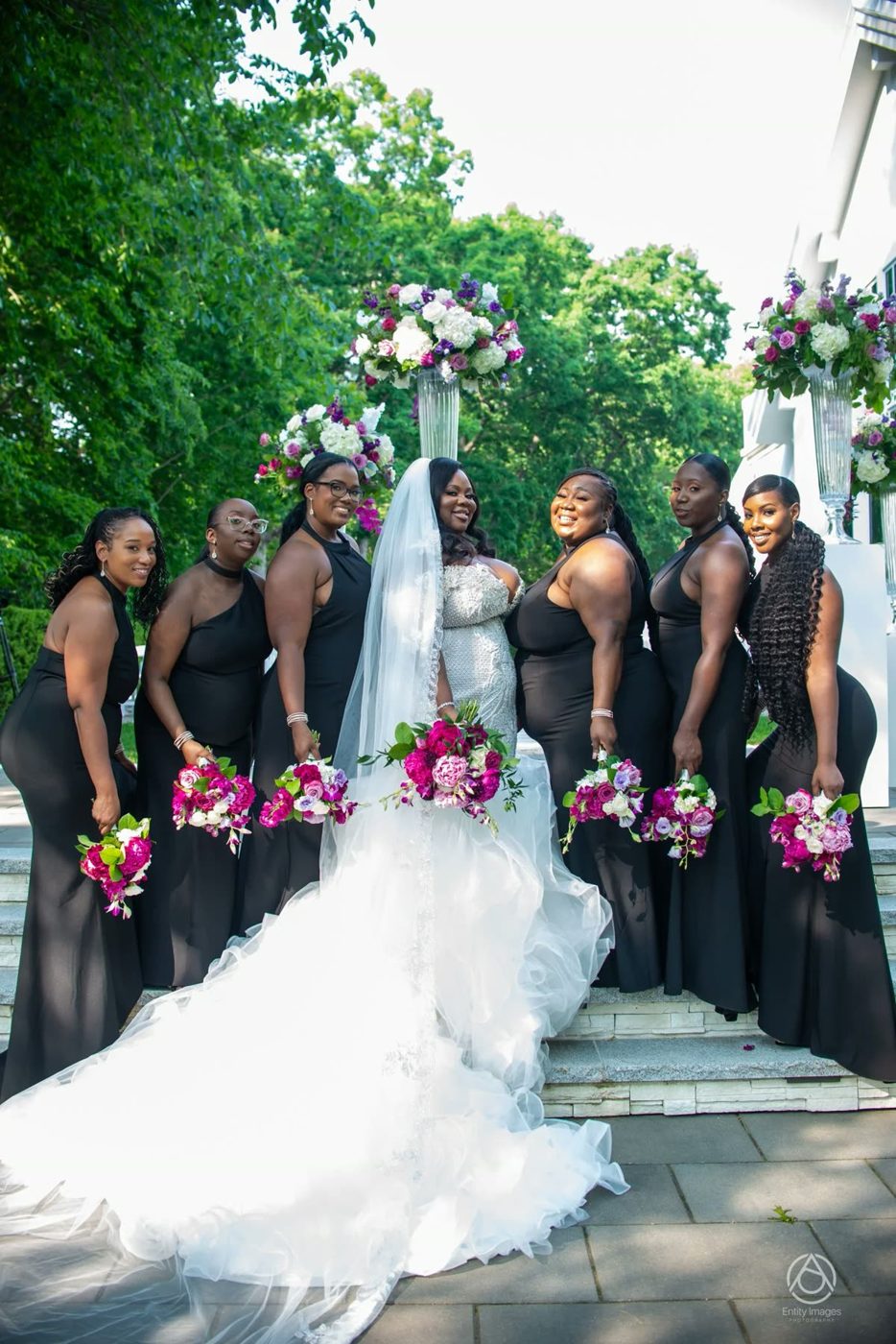 Bride with bridesmaids in black holding fuchsia bouquets
