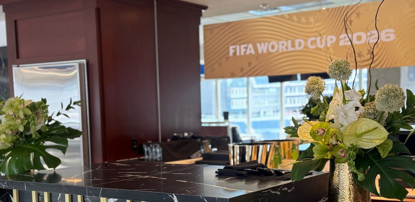Marble suite bar lined with gold vase arrangements beneath the FIFA World Cup wall