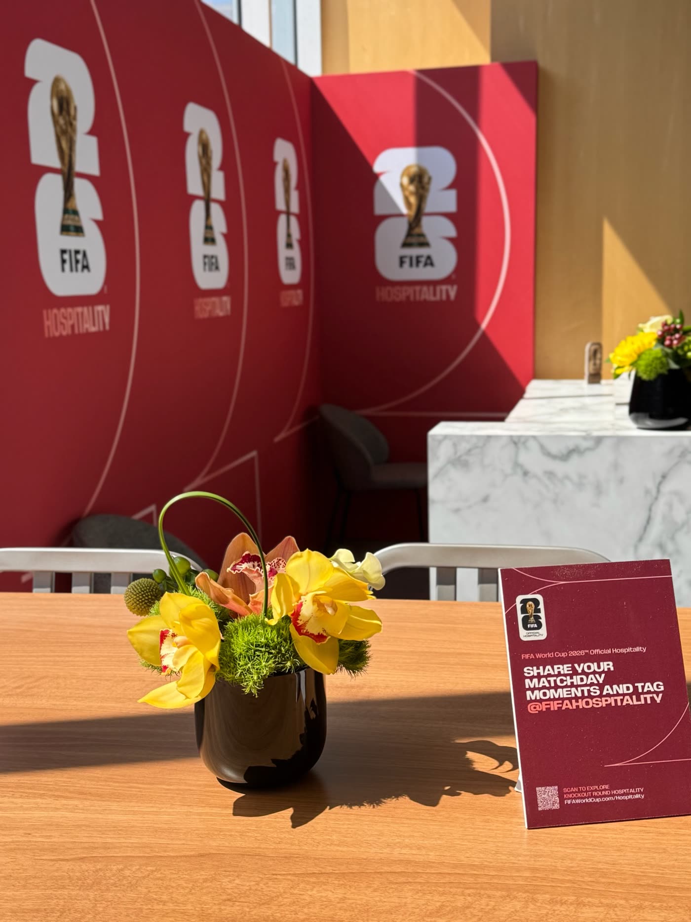 Yellow orchid centerpiece against the red FIFA Hospitality wall