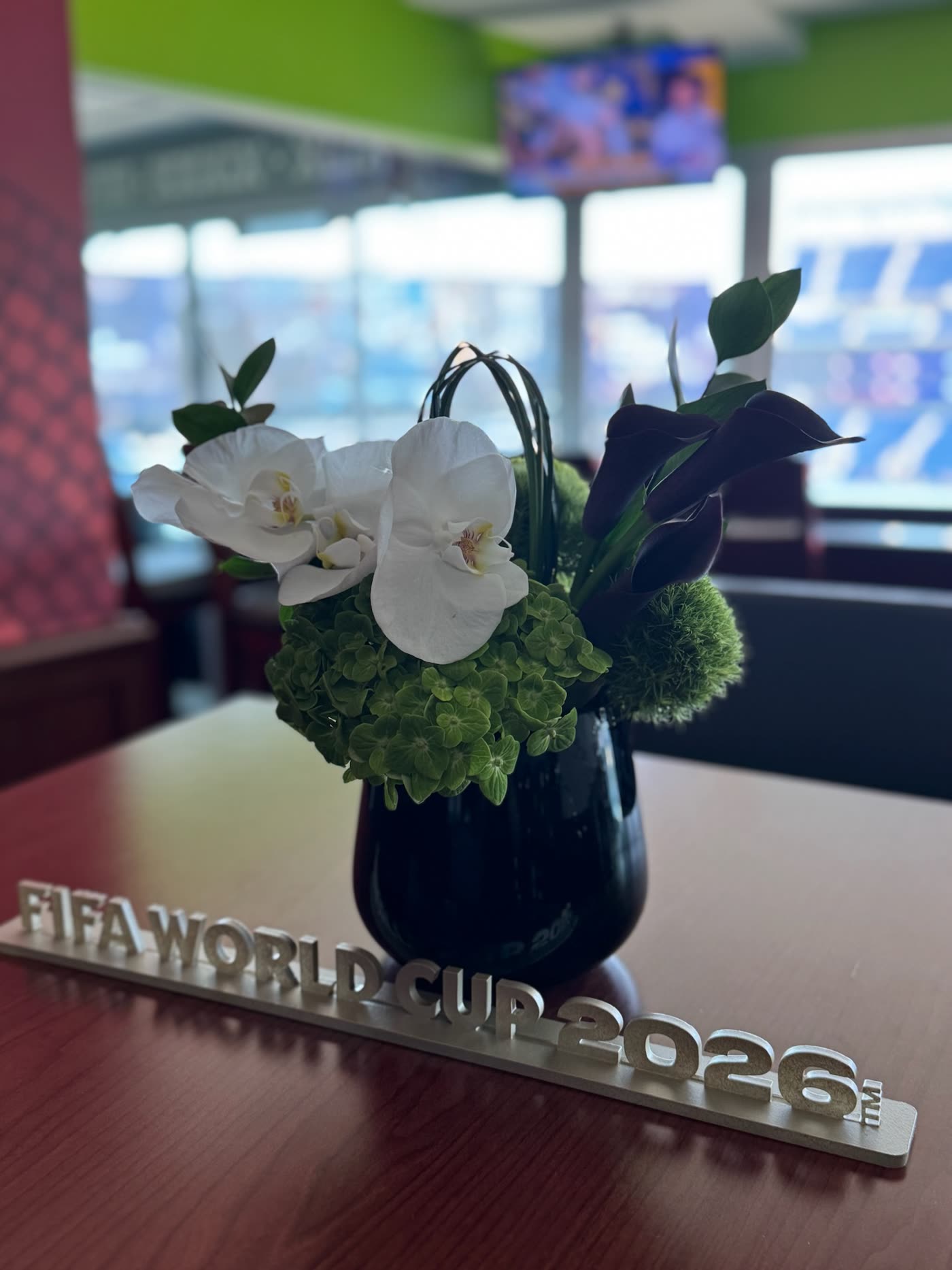 Orchid arrangement beside the FIFA World Cup 2026 marque