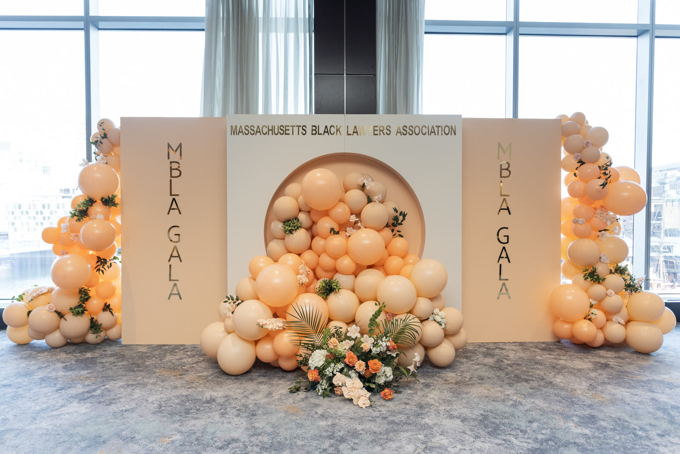 Peach balloon garlands framing the gala step-and-repeat