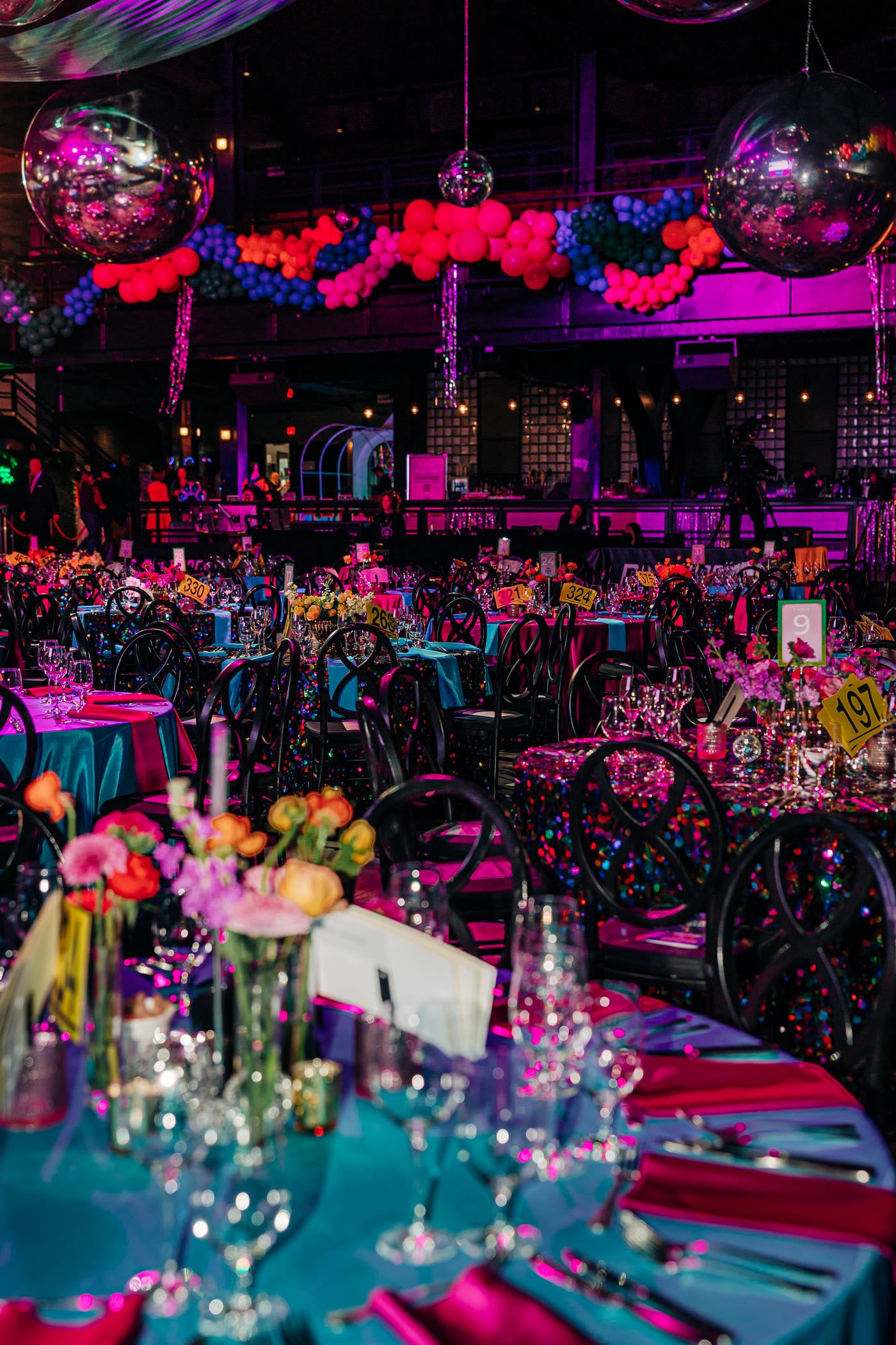 Disco-lit gala room dressed in fuchsia and teal