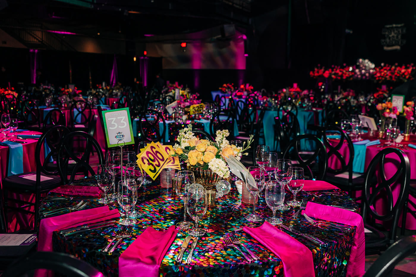 Fuchsia linens, teal chairs and a yellow floral centerpiece