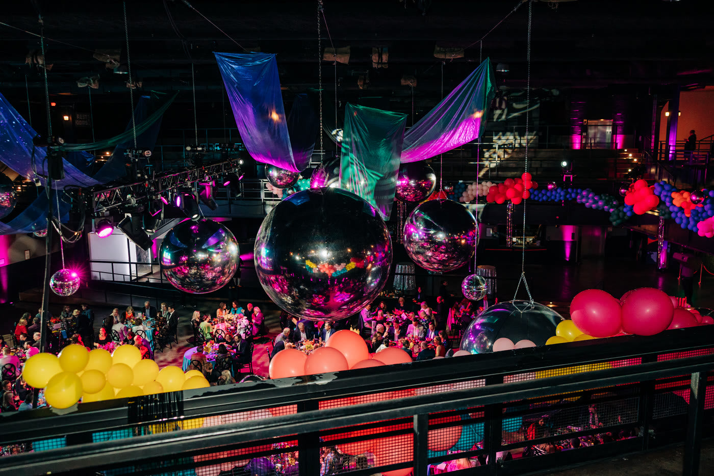 Disco balls and balloon garlands over the benefit floor