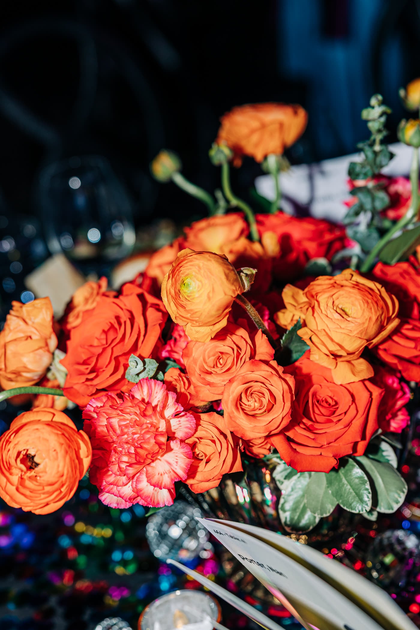 Orange ranunculus and roses, up close