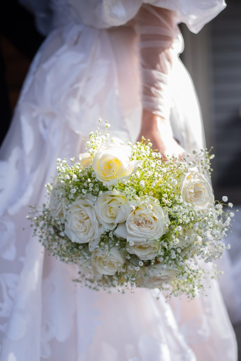 A hand-tied bouquet of white garden roses and baby&rsquo;s breath
