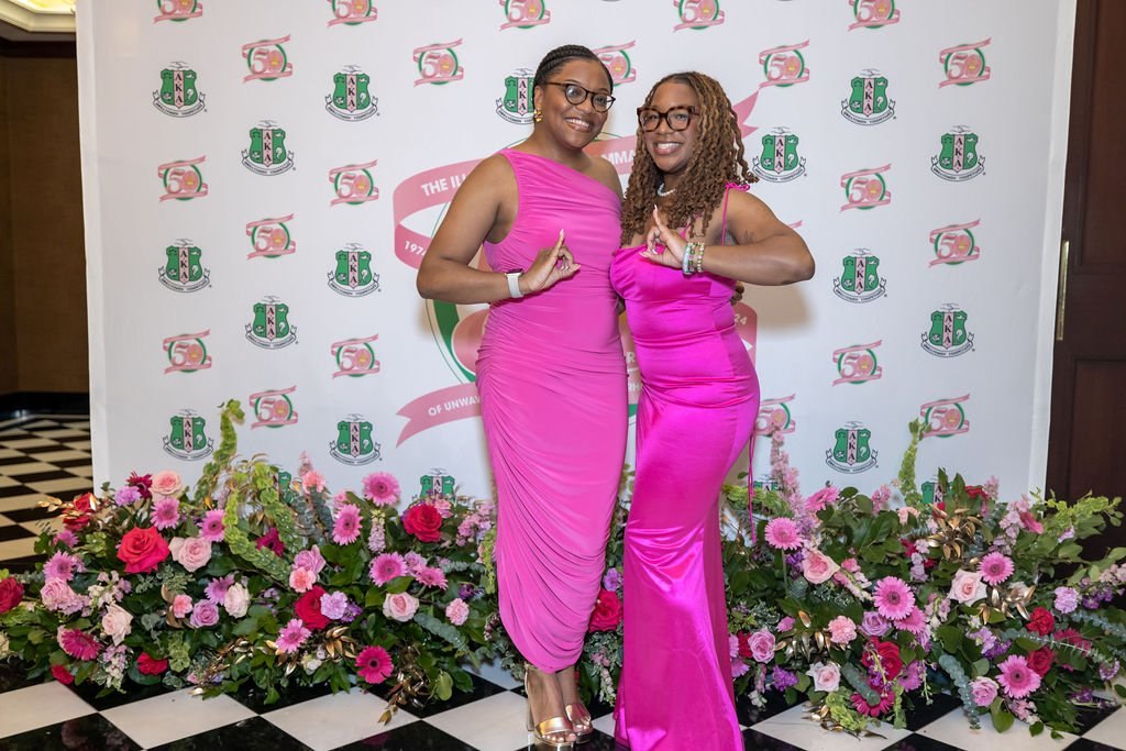 Pink and green at the AKA Iota Gamma 50th step-and-repeat