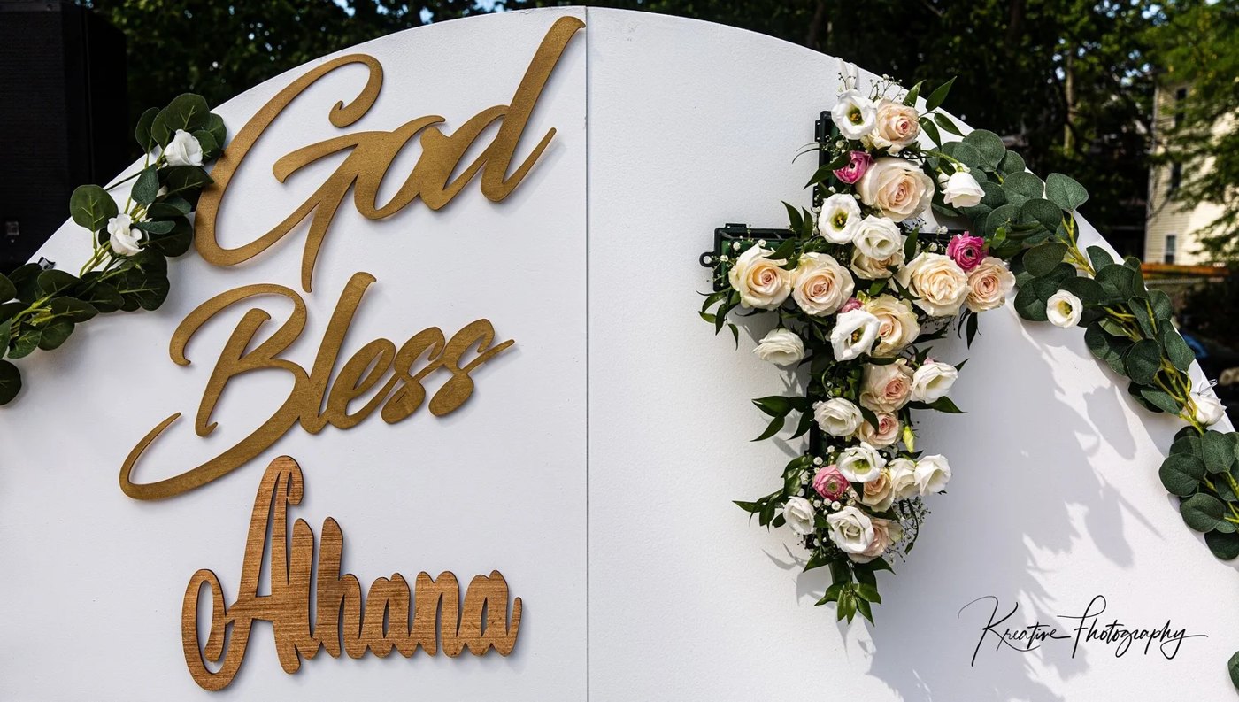 The floral cross beside God Bless Alhana