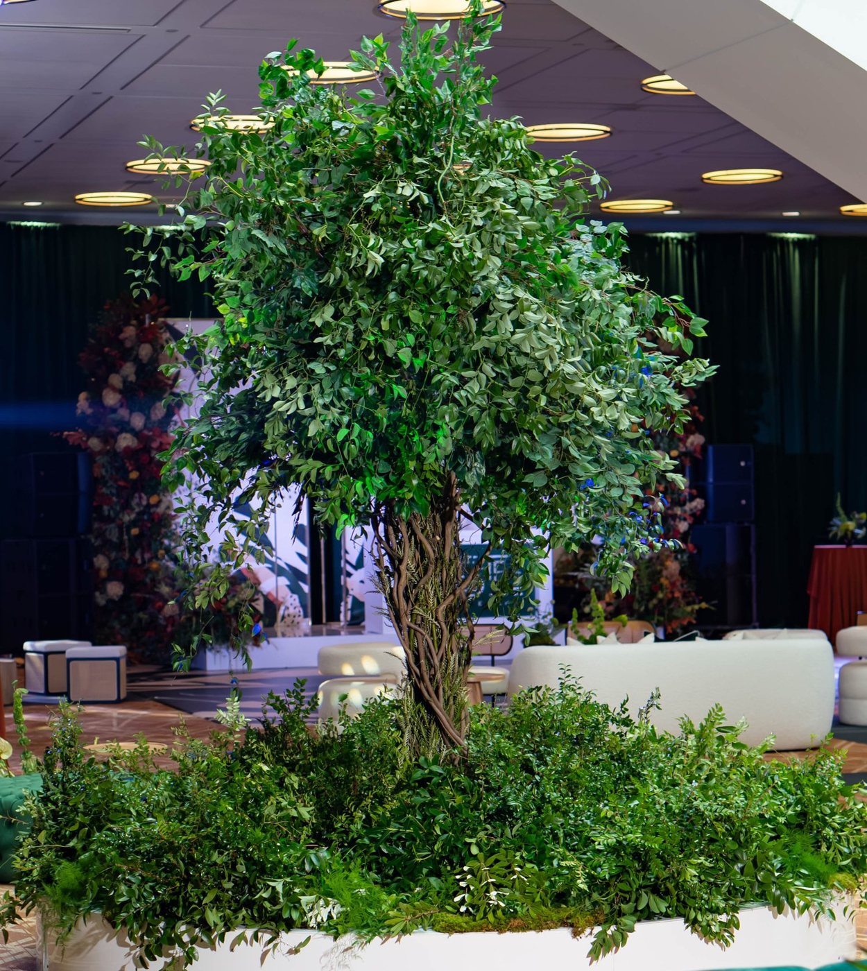 A fourteen-foot tree installation ringed in greenery
