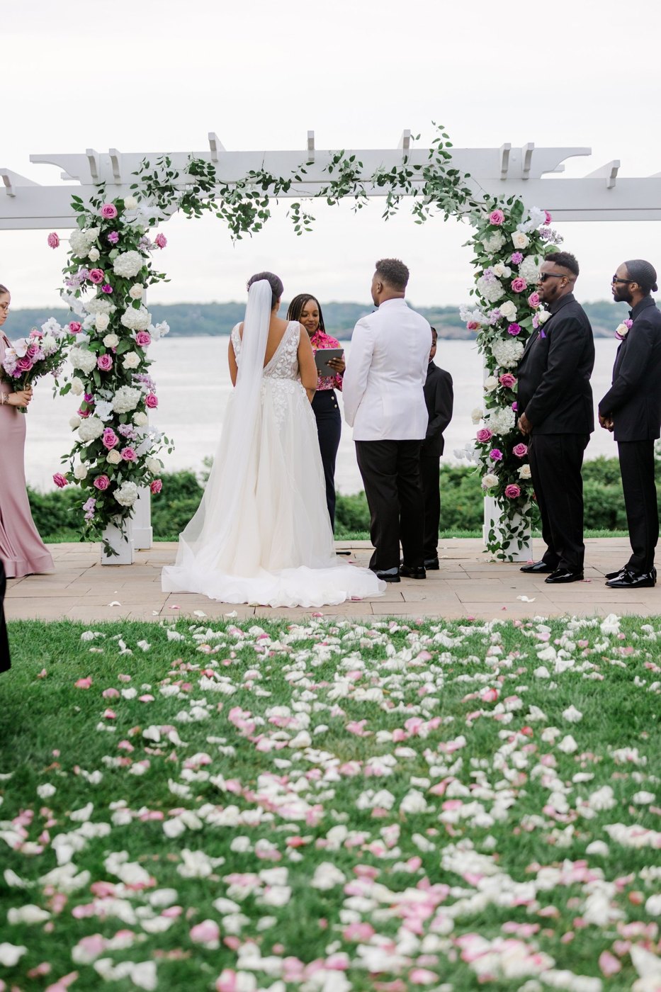 The floral arch over the water, petals down the aisle