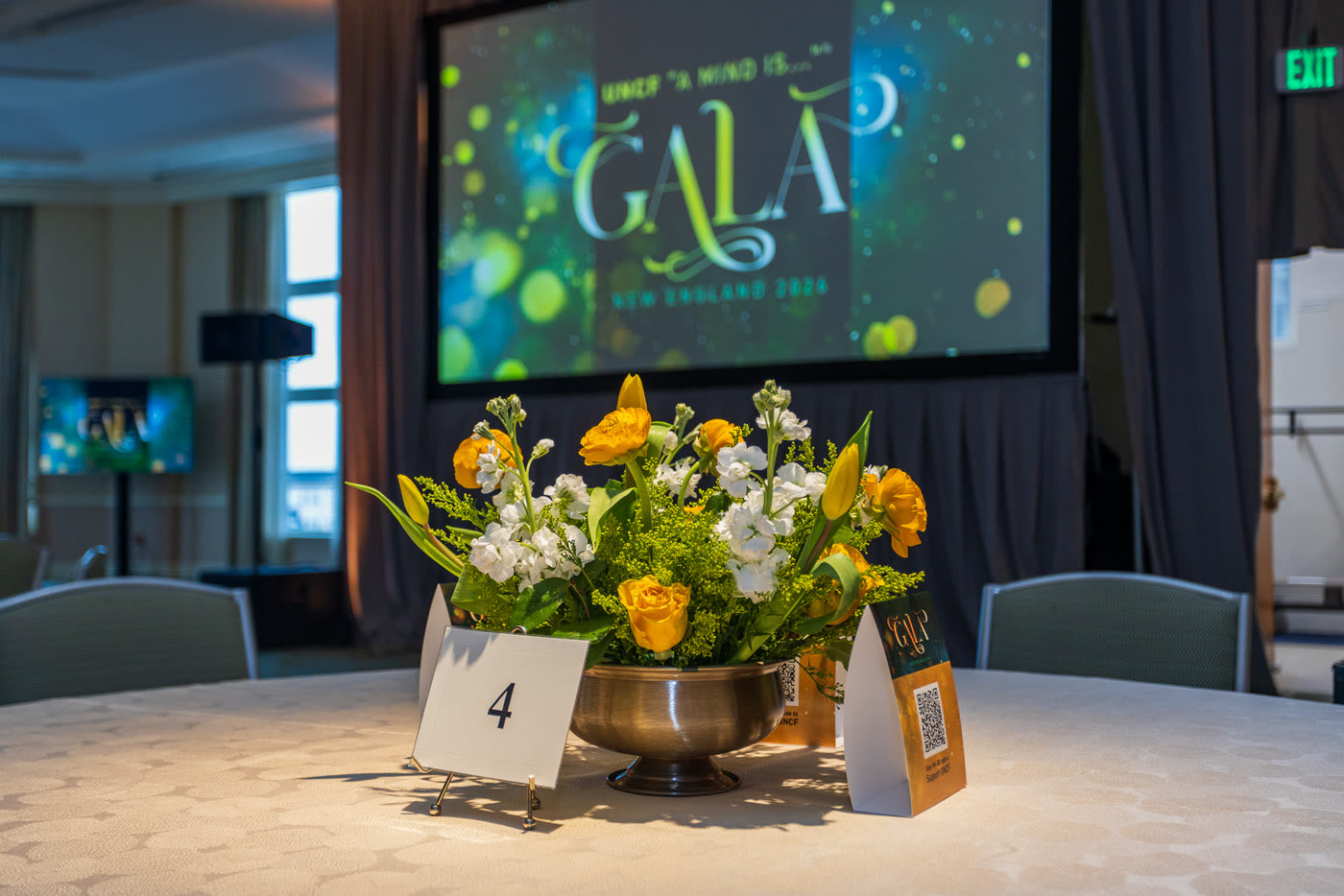 Gala table four, yellow centerpiece beneath the screen