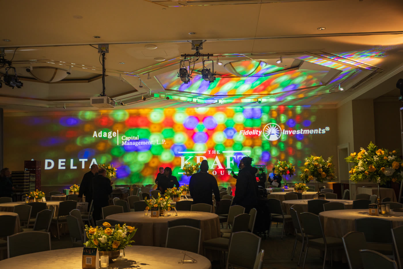 Branded screens washed in color over the gala floor
