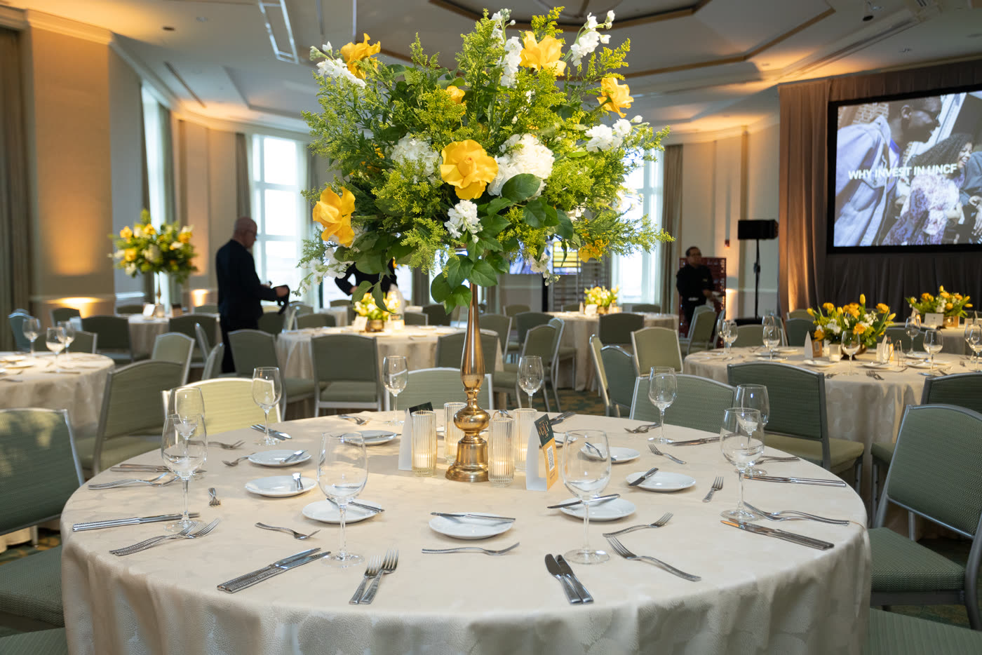 Towering yellow and white centerpiece on a gold stand