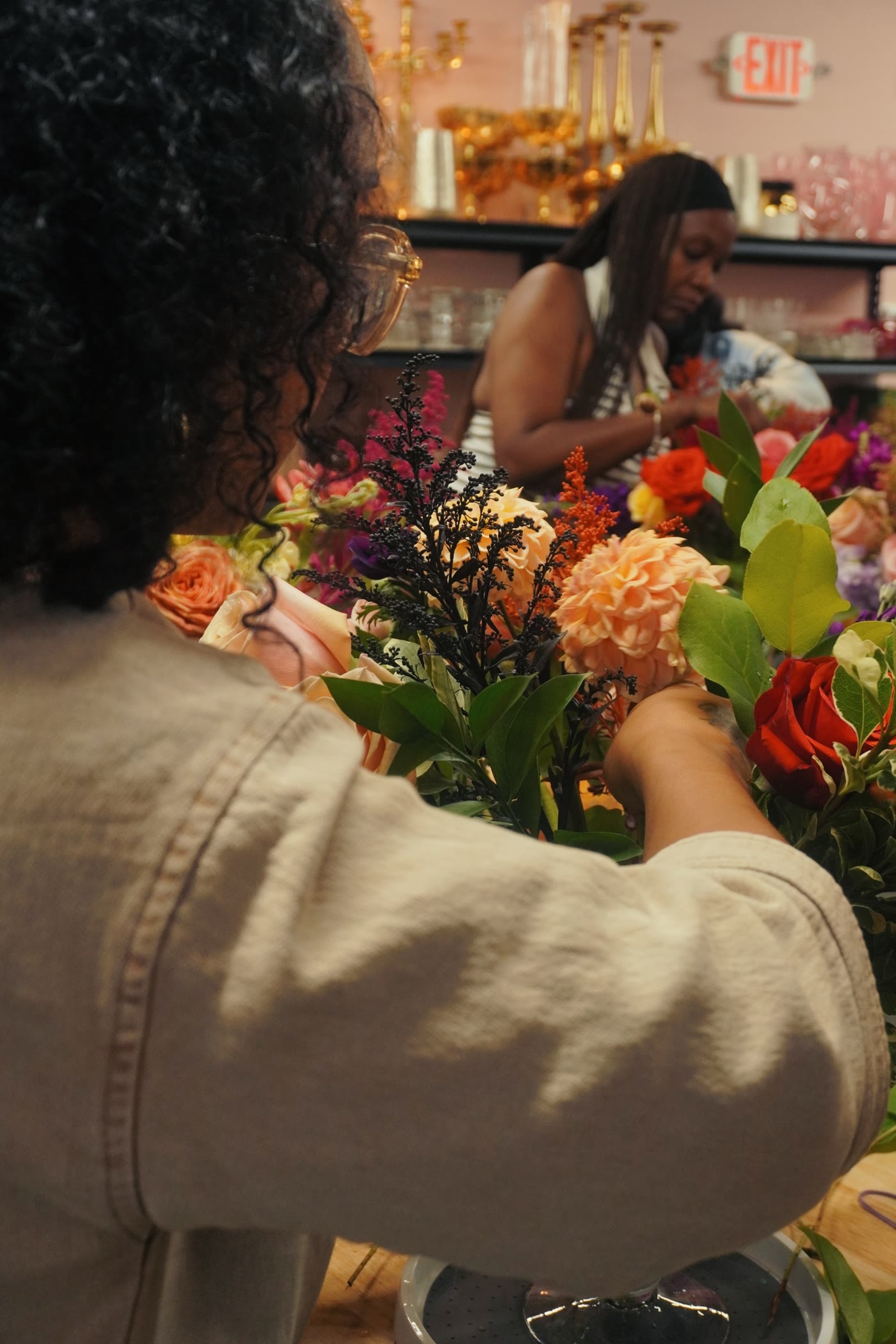 Hands at work — a guest builds her arrangement