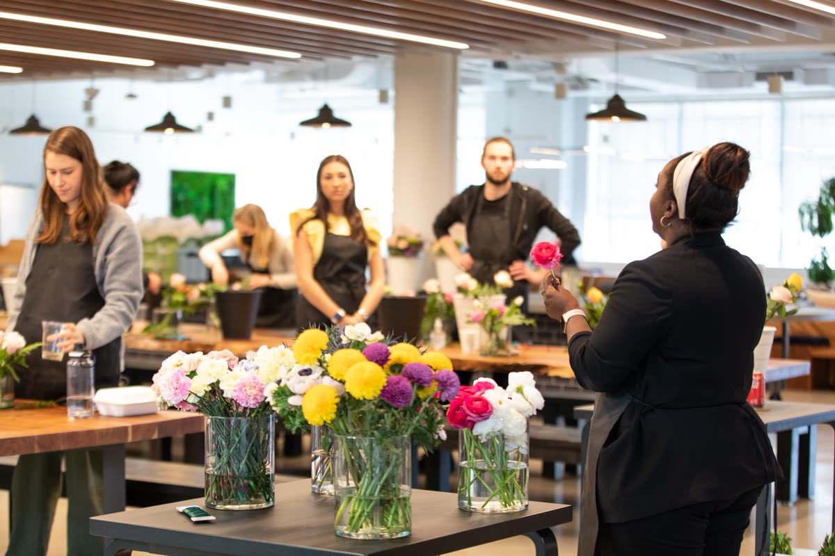 Yanique teaching a floral workshop, holding a ranunculus