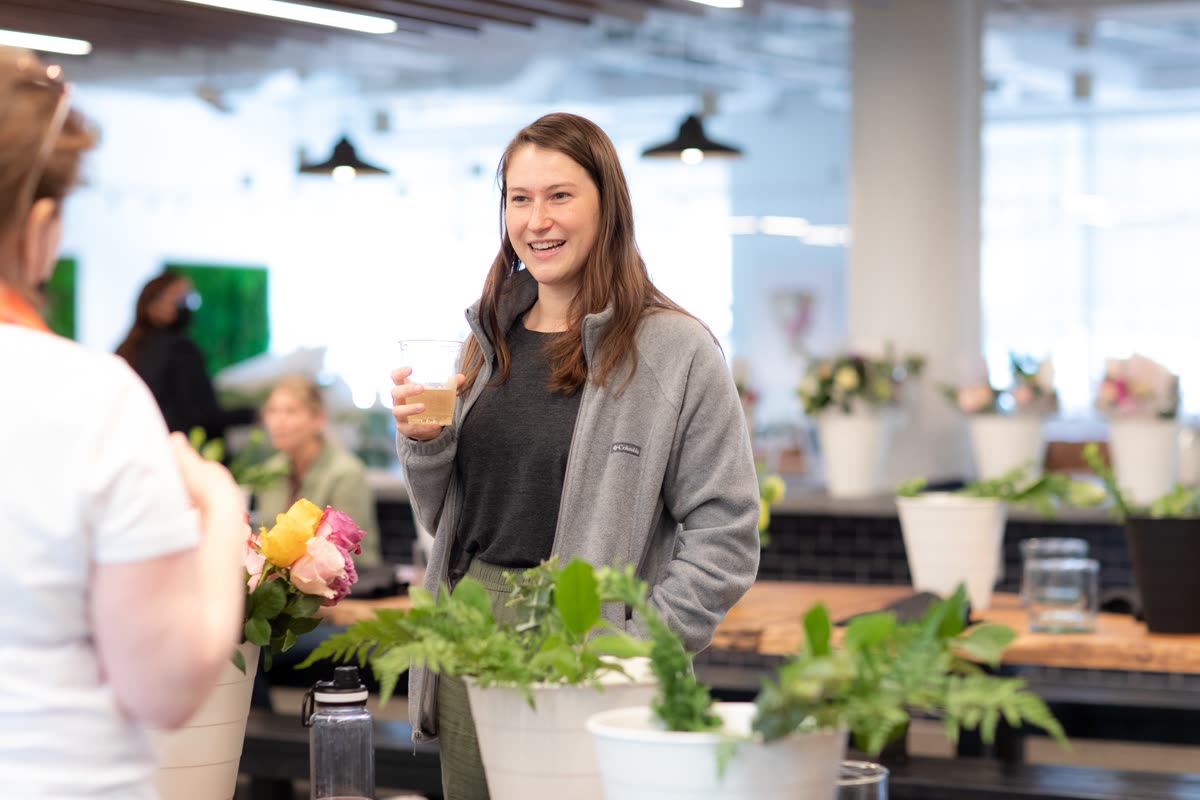 A guest at a corporate workshop smiling over arrangements